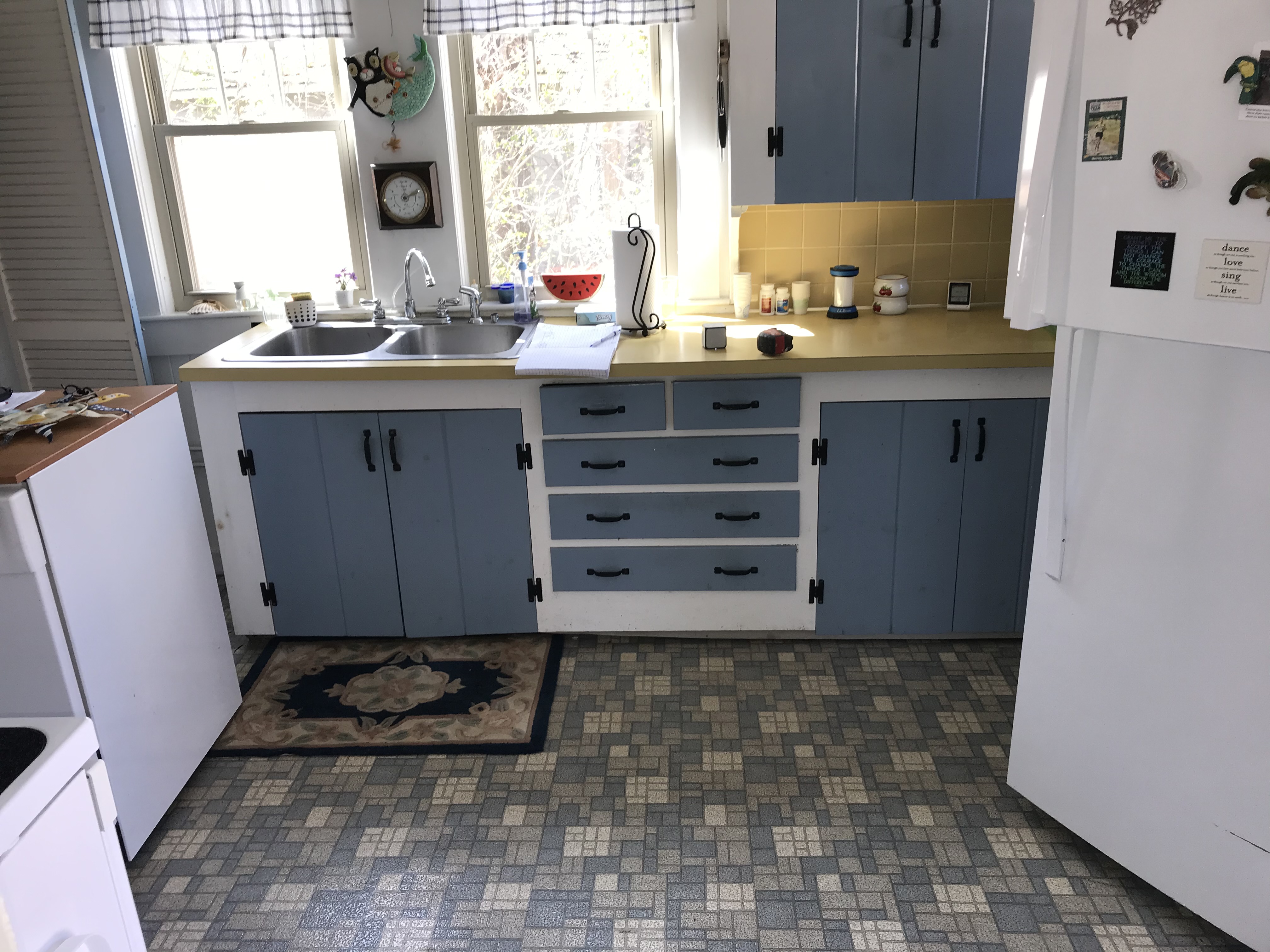 Dark outdated kitchen with wooden cabinets and worn tile floor before renovation by Bulldog Construction